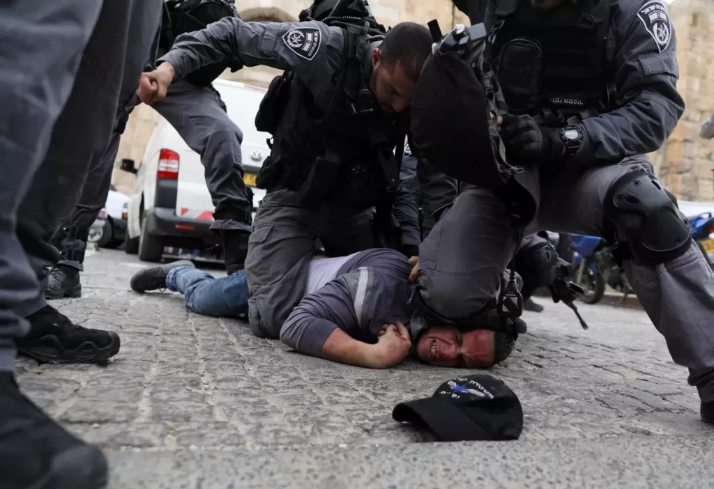 Israeli officer kneeling on a Palestinian man's neck
